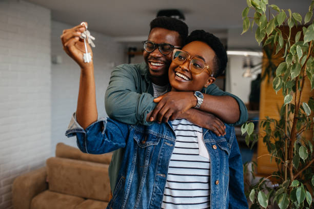Happy young couple holding key to new home on moving day